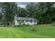 Scenic view of single story home with well-manicured lawn and mature trees, close to the lake at 106 Palomino Cv, Louisburg, NC 27549