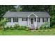 Charming single story home with gray siding, black shutters and inviting front porch with pretty landscaping at 106 Palomino Cv, Louisburg, NC 27549
