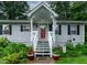 Charming home entrance with white stairs, a bright red door and potted flowers at 106 Palomino Cv, Louisburg, NC 27549