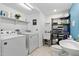 Well-organized laundry room with washer, dryer, sink, and shelving for storage at 106 Palomino Cv, Louisburg, NC 27549