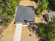 High aerial shot of the home surrounded by dense trees, a long driveway, and a well-kept lawn at 107 Seminole Dr, Louisburg, NC 27549