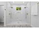 Bright bathroom featuring a dual shower, a window, and elegant marble tiling from floor to ceiling at 107 Seminole Dr, Louisburg, NC 27549