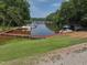Scenic lake view with a long wooden dock and boats, surrounded by lush green trees at 107 Seminole Dr, Louisburg, NC 27549