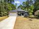 Charming single-story home featuring stone accents, a gray facade, and a well-manicured front yard at 107 Seminole Dr, Louisburg, NC 27549