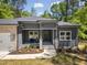 Inviting front porch with stone pillars, manicured flower bed and seating for relaxing outdoors at 107 Seminole Dr, Louisburg, NC 27549