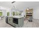 Open-concept kitchen with modern island, stainless steel appliances, and adjacent stone fireplace in living area at 107 Seminole Dr, Louisburg, NC 27549