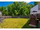 Expansive fenced backyard, showcasing lush green grass, mature trees, and play equipment at 11 Piccadilly Ct, Durham, NC 27713
