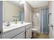 Bright bathroom features a double sink vanity and a shower-tub combination with a blue shower curtain at 11 Piccadilly Ct, Durham, NC 27713
