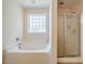 Bright bathroom with soaking tub, glass shower, and tiled floors at 11 Piccadilly Ct, Durham, NC 27713