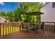 Wooden deck with an umbrella table and chairs overlooking a large backyard and mature trees at 11 Piccadilly Ct, Durham, NC 27713