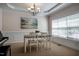 Well-lit dining room featuring a chandelier, large window, and a table with four white chairs at 11 Piccadilly Ct, Durham, NC 27713
