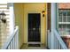 Close-up of a black front door with a decorative lantern, set against yellow siding and brick accents at 11 Piccadilly Ct, Durham, NC 27713