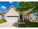 Inviting two-story home featuring a combination of siding and brick, with a two-car garage and manicured front lawn at 11 Piccadilly Ct, Durham, NC 27713