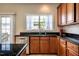 Well-lit kitchen features wood cabinets, stainless steel dishwasher and a window with backyard views at 11 Piccadilly Ct, Durham, NC 27713