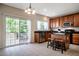 Bright kitchen featuring tile floors, wood cabinets, an island with seating, and sliding glass doors to the deck at 11 Piccadilly Ct, Durham, NC 27713