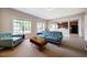 Cozy living room with carpet floors, two windows, and view into the kitchen at 11 Piccadilly Ct, Durham, NC 27713
