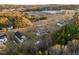 Wide aerial shot showing the community and surrounding amenities including school, road, and forest at 1101 Ridge Rd, Roxboro, NC 27573