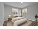 Stylishly staged bedroom with hardwood floors, a plush rug, and natural light from dual windows at 1101 Ridge Rd, Roxboro, NC 27573