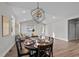 Open-concept dining room boasts modern chandelier, hardwood floors, and ample natural light at 1101 Ridge Rd, Roxboro, NC 27573