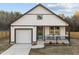 Charming exterior featuring white vertical siding, a cozy porch, and a convenient one-car garage at 1101 Ridge Rd, Roxboro, NC 27573