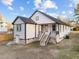 Rear exterior view featuring white siding, a basement entrance, and steps leading to the back door at 1101 Ridge Rd, Roxboro, NC 27573