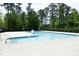 Community pool area surrounded by a safety fence and lush trees at 1106 Red Crest Ln, Durham, NC 27704