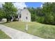 View of the side of a two-story home from the street, showcasing the lush greenery at 1106 Red Crest Ln, Durham, NC 27704