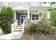 Inviting front porch with stone accents, white railings, and colorful landscaping at 1106 Red Crest Ln, Durham, NC 27704