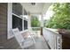 Cozy front porch featuring rocking chairs, white railings, and beautiful landscaping at 1106 Red Crest Ln, Durham, NC 27704