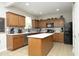 Well-lit kitchen featuring wooden cabinetry, stainless steel appliances, an island, and a tiled backsplash at 1106 Red Crest Ln, Durham, NC 27704