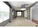 Bright living room featuring large windows, a bar, and an open floor plan leading to the entrance at 1106 Red Crest Ln, Durham, NC 27704