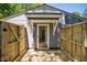 New wooden deck and privacy fence lead to this home's entrance with glass door, under bright sun at 112 Carmichael Ct, Cary, NC 27511
