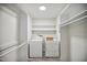 Organized laundry room featuring washer, dryer, shelving, and overhead lighting at 112 Carmichael Ct, Cary, NC 27511