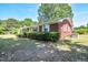 Side view of a brick house with white framed windows, surrounded by lush green grass and trees at 11234 Nc Hwy 50, Benson, NC 27504