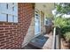 Close-up of the front door, brick facade with stone accents, and a small covered porch at 11234 Nc Hwy 50, Benson, NC 27504