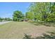 Large front yard of a brick home with mature trees on a sunny day at 11234 Nc Hwy 50, Benson, NC 27504