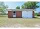 Exterior view of a detached brick garage featuring a sliding door and a convenient side door entrance at 11234 Nc Hwy 50, Benson, NC 27504