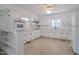 Spacious kitchen featuring white cabinetry, neutral tile flooring, and ample natural light at 11234 Nc Hwy 50, Benson, NC 27504