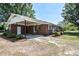 Exterior rear view showcasing a brick facade with a carport and a spacious lot at 11234 Nc Hwy 50, Benson, NC 27504