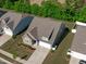 An aerial view of a well-maintained lawn with mature landscaping, a paved driveway, and green grass at 116 Alumroot Rd, Holly Springs, NC 27540