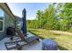 Backyard with lounge seating, blue umbrella, and privacy fence at 116 Alumroot Rd, Holly Springs, NC 27540