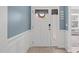 Bright entryway boasts wainscoting detail, a transom window, and elegant decor for a welcoming ambiance at 116 Alumroot Rd, Holly Springs, NC 27540