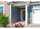 Charming front entrance with a covered porch, black front door, and lovely red flowers at 116 Alumroot Rd, Holly Springs, NC 27540