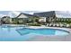 Community pool with a zero entry, chairs and tables for sunbathing, and a clubhouse at 116 Alumroot Rd, Holly Springs, NC 27540