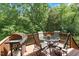 Outdoor deck featuring a grill, table, and chairs, perfect for entertaining guests with tree views at 116 Weaver Mine Trl, Chapel Hill, NC 27517