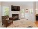 Bright living room featuring a fireplace, a comfortable accent chair, and ample natural light at 116 Weaver Mine Trl, Chapel Hill, NC 27517