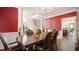 Elegant dining room featuring hardwood floors, large windows, and a statement red accent wall at 1258 Jamestowne Dr, Elon, NC 27244