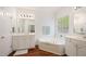Bright main bathroom with dual vanities, a large soaking tub, and ample storage space at 1258 Jamestowne Dr, Elon, NC 27244