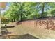 Backyard featuring grass, trees, retaining wall, and fenced border at 127 Deacon Ridge St, Wake Forest, NC 27587