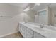 Bathroom with double sinks, white cabinets, large mirror and tiled floors at 127 Deacon Ridge St, Wake Forest, NC 27587